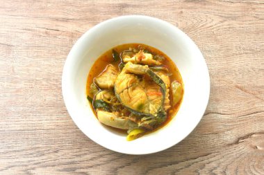 Baharatlı biber, patlıcan ve fesleğen ile kaynatılmış yayın balığı.