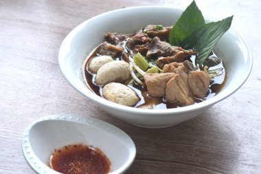 haşlanmış domuz tendonu ve fasulye filizli köfte. Kahverengi fesleğenin üstünde taze fesleğen. Baharatlı acı biber sosu.