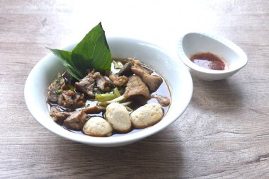 haşlanmış domuz tendonu ve fasulye filizli köfte. Kahverengi fesleğenin üstünde taze fesleğen. Baharatlı acı biber sosu.