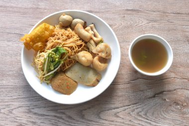 Kuru sarı erişteli erişte dory balığı ve fasulye filizli balık köftesi tabakta çıtır köfte ve çorba.