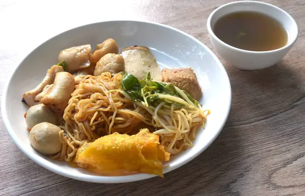 Kuru sarı erişteli erişte dory balığı ve fasulye filizli balık köftesi tabakta çıtır köfte ve çorba.