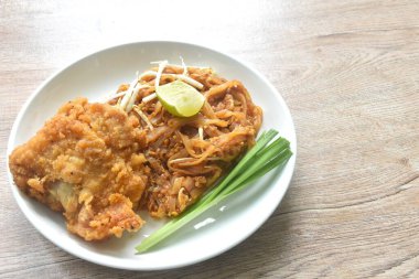 Pad Thai karıştırılmış kızarmış pirinç eriştesi ile karides ve yumurta soslu kızarmış tavuk tabağı. 