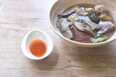 Haşlanmış domuz kanı ve domuz pirzolası, siyah mantar soslu ve baharatlı acı biber soslu çorba. 