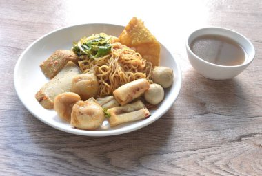 Kuru sarı erişteli erişte dory balığı ve fasulye filizli balık köftesi tabakta çıtır köfte ve çorba.