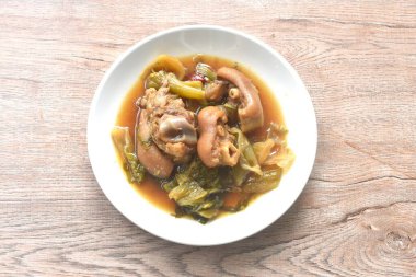 haşlanmış tuzlu domuz budu ve Çin sebzeli kahverengi çorbada salamura lahana.