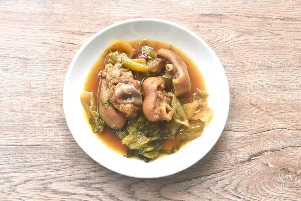 haşlanmış tuzlu domuz budu ve Çin sebzeli kahverengi çorbada salamura lahana.