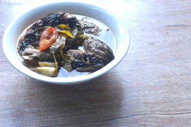 Baharatlı ve ekşi çorbayla pişirilmiş kuru yılan başı balığı.