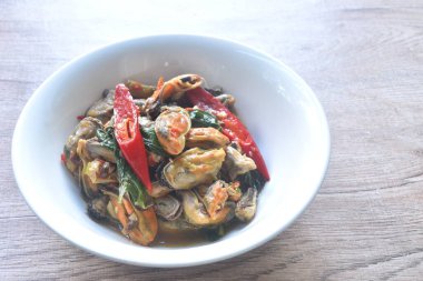 Acı biberli kızarmış midye ve köri soslu fesleğen yaprağı.