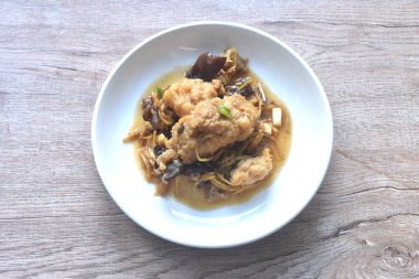 spicy deep fried chop Nile Tilapia or mango fish slice ginger and ear mushroom couple celery dressing soy sauce on plate 