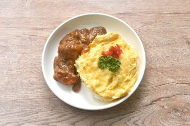 Sade pirinç soslu patates ve tabakta Japon köri soslu havuç soslu kremalı omlet. 