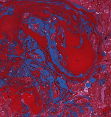 Spilled red, blue and white paint on the thinner solution. Selective focus on pink background.