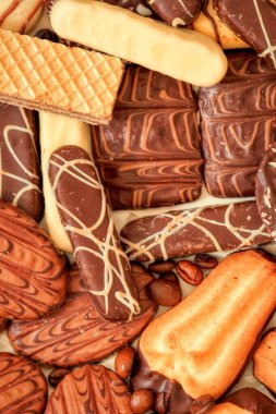 Bisküviler tabağın üstünde, kurabiyeler ahşap boş tahta arka planda. Makro tatlılar. Lezzetli bisküviler ve çikolatalar yakın.