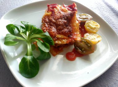 Lasanya ist ein trationelles italienisches Gericht, bestehend aus abwechselnden Schichten von Nudelplatten, Hackfleischsauce, Bchamelsauce und Kse. Eveeeeeeeeet gebacken ve ein beliebtes Familienessen.