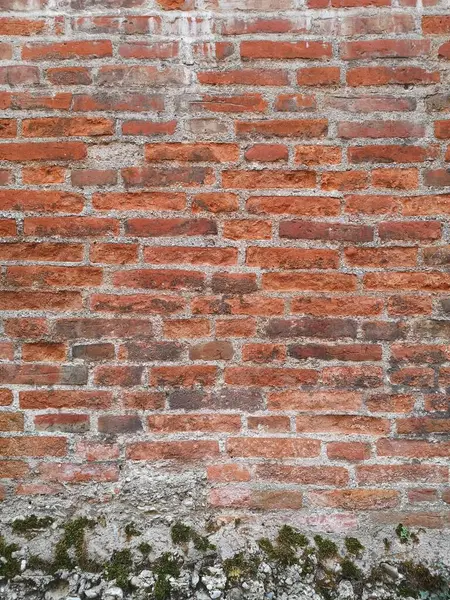 Die rote Ziegelmauer erstreckt sich majtisch in die Hhe, ihre robusten Steine strahlen Wrme und Bestndigkeit aus. Ein zeitlose Bauwerk, das Geschichten zu erzhlen scheint.