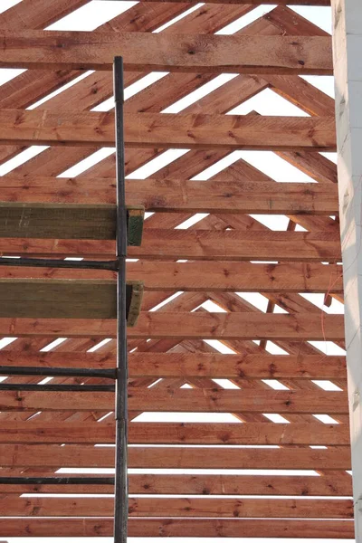 A timber roof truss in a house under construction and a scaffolding