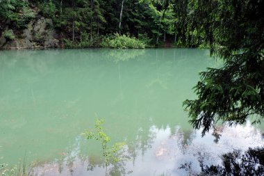 Rudawy Janowickie, Sudetes dağları ve Polonya 'daki ağaçlar arasında masmavi bir lakelet manzarası