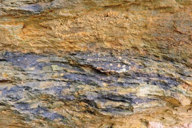 Kükürt ve pirit içeren kahverengi ve turuncu tortulu bir kaya.