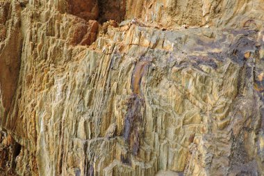 Kükürt ve pirit içeren kahverengi ve turuncu tortulu bir kaya.