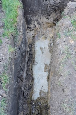 Derin kazılar kısmen yeni bir eve beton döşemek için yapılmış suyla dolu.