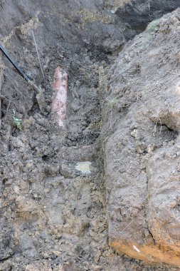 Bataklıktaki derin hendek ve plastik turuncu boru beton bir lağım çukurunun yanında.