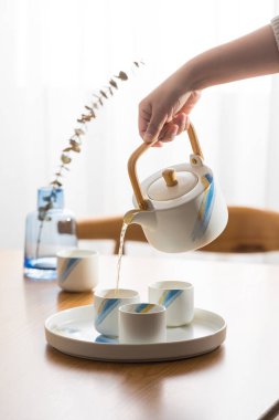 Çay takımı resmi, Asya tarzı çay, çay fincanı ve çaydanlık yapan kişi.