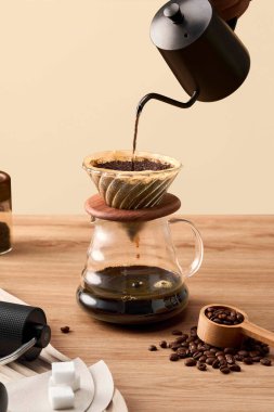 Kahve İçme Süreci 'nin Üzerine Taze Demlenmiş Kahve, Cam Sunucu' nun içine dökülen Kahve Ahşap bir sehpanın üzerindeki gayzer kahve makinesine             