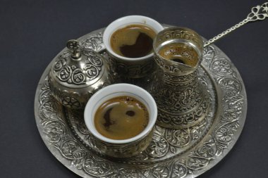 Kahve çekirdekleri ve bir fincan demlenmiş kahve. Doğu usulü kahve içme seti.