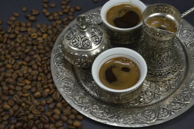 Kahve çekirdekleri ve bir fincan demlenmiş kahve. Doğu usulü kahve içme seti.