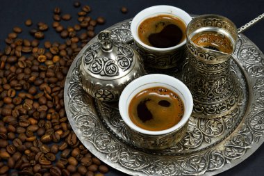 Kahve çekirdekleri ve bir fincan demlenmiş kahve. Doğu usulü kahve içme seti.