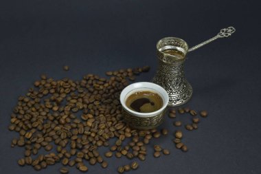 Kahve çekirdekleri ve bir fincan demlenmiş kahve. Doğu usulü kahve içme seti.