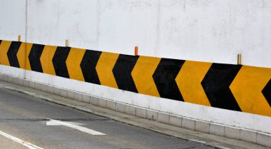 Hareket yönü için yeraltı garajının duvarındaki trafik işaretleri.