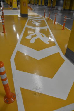 Şehirdeki alışveriş merkezinin yeraltı garajındaki yayalar için trafik işaretleri