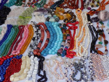 İnci ve boncuklardan yapılmış renkli kolyeler ve bilezikler.