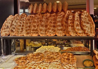 Pita ekmeği, çeşitli hamur işleri ve tatlılar fırının rafında.