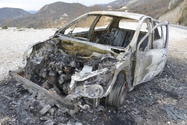 Araba kazasından sonra yolun kenarındaki otoparkta yanmış.