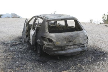 Araba kazasından sonra yolun kenarındaki otoparkta yanmış.