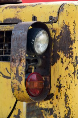 Eski, sarı kepçenin parçaları, tarlada terk edilmiş.