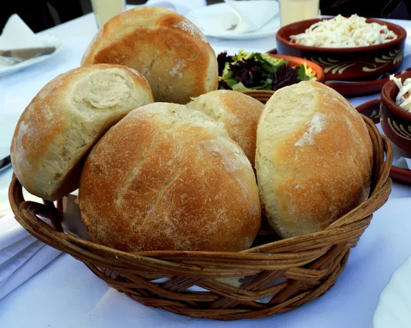在餐馆桌子上的柳条篮里夹着面包 — 图库照片