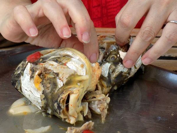 Woman cleaned boiled fish heads for fish soup
