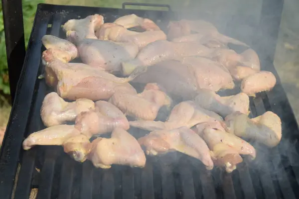 stock image Chef puts rosemary on the chicken meat that is baked on the grill