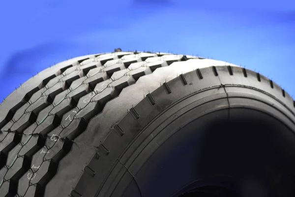 stock image Detail of car tire for heavy construction equipment and engineering vehicle, on a blue background