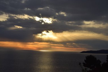 Açık denizde gün batımı, bulutlu gökyüzü