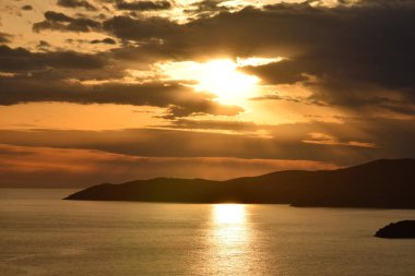 Açık denizde gün batımı, bulutlu gökyüzü