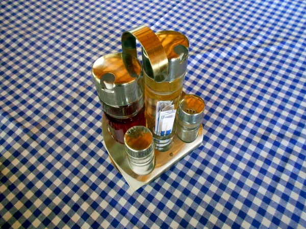 Jugs for spices on the plaid tablecloth in the restaurant