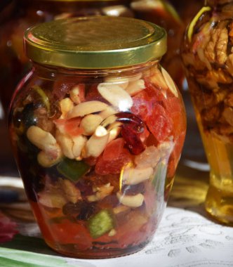 Bal içinde saklanmış fındık ve kurutulmuş meyve dolu kavanozlar.