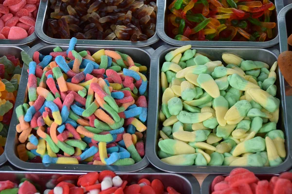 Sweets and candies of various colors and shapes on the counter in the candy shop
