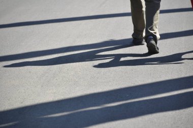 El ele tutuşup yürüyen çiftin bacakları ve gölgeleri
