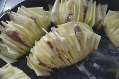 Pastırma ve peynirle doldurulmuş patatesler pişirmeye hazır.