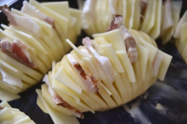 Pastırma ve peynirle doldurulmuş patatesler pişirmeye hazır.
