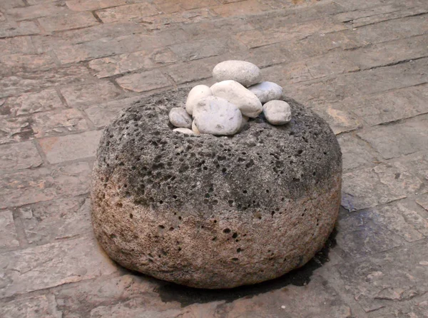 大圆石顶部有几个小圆石的大圆石 屹立在人行道上 — 图库照片